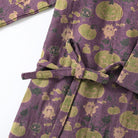Purple kimono with tied belt, green pumpkin and monster print, flat lay closeup | Chaps London