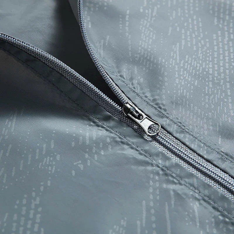 Close-up of gray zipper on patterned windbreaker fabric, flat lay view | Chaps London