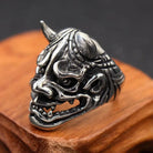 Silver Oni demon ring with horns, displayed on wooden stand | Chaps London
