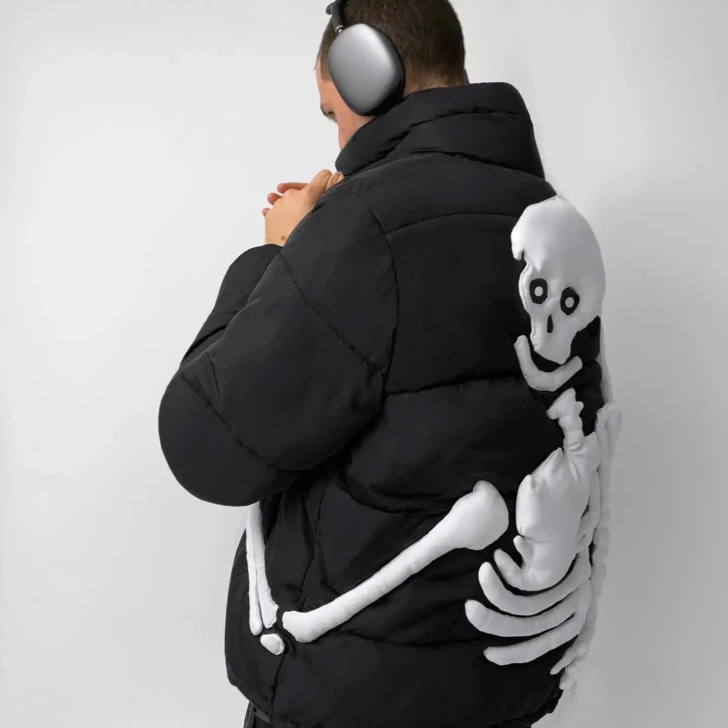 Man wearing black puffer jacket with white skeleton arm graphic on back | Chaps London