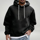 Black relaxed hoodie with white drawcords, worn by a man, layered over white shirt | Chaps London