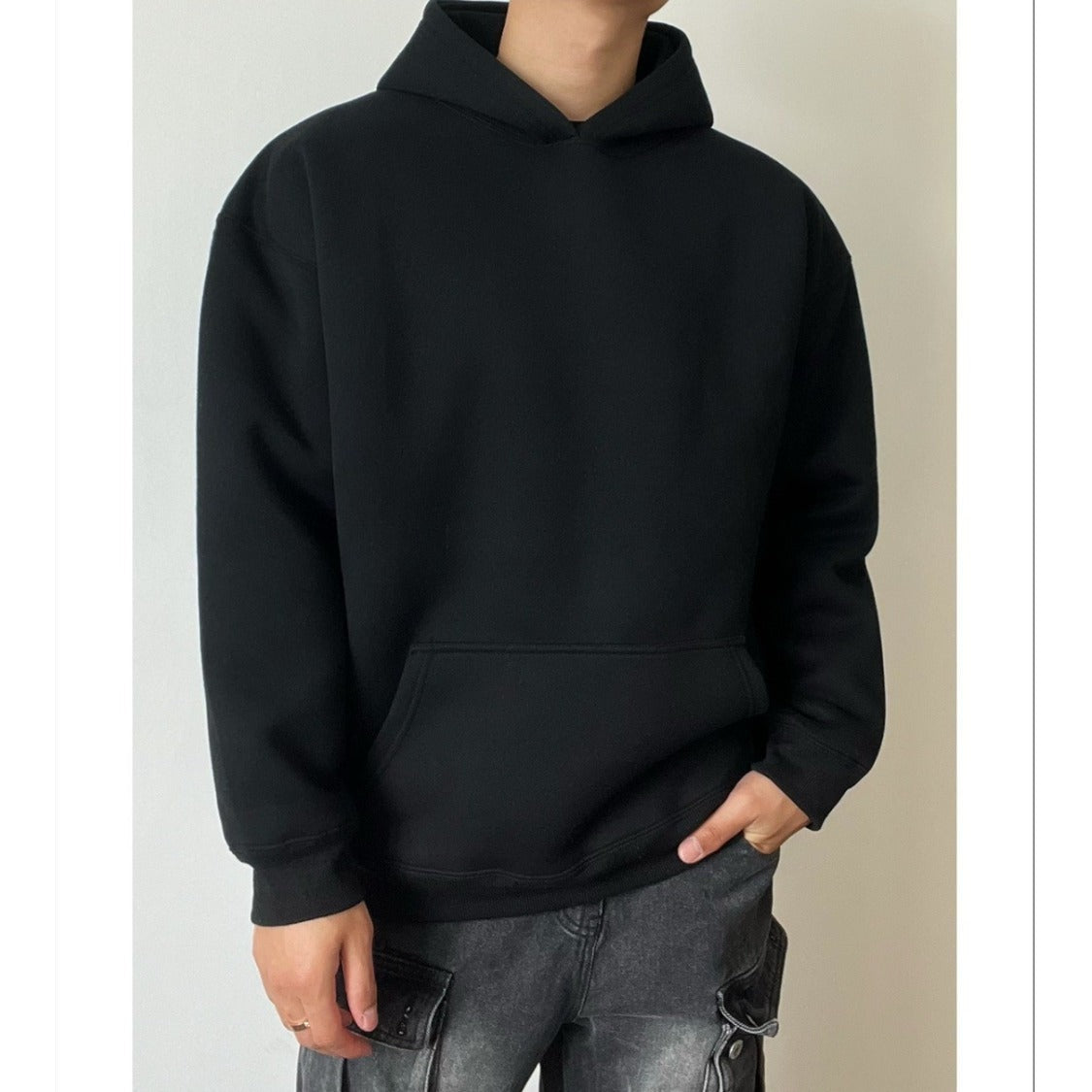 Man wearing plain black oversized hoodie with kangaroo pocket, front view | Chaps London