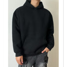 Man wearing plain black oversized hoodie with kangaroo pocket, front view | Chaps London
