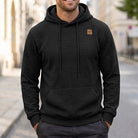 Black quilted-texture hoodie with chest patch worn by man outdoors | Chaps London