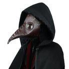 Brown plague doctor mask with rivets worn over black hooded cloak | Chaps London