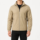Man wearing beige zip-up rain jacket with black pants, standing | Chaps London