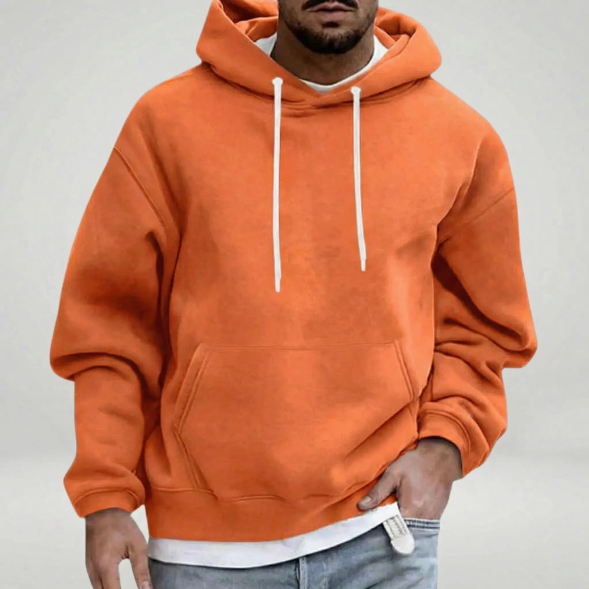 Man wearing orange hooded sweatshirt with white drawstrings, layered white shirt underneath | Chaps London