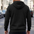 Black textured quilted hoodie worn by man, back view, outdoor street setting | Chaps London