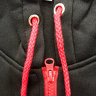 Black hoodie close-up with red drawstrings and red zipper detail | Chaps London