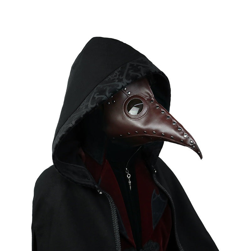 Brown plague doctor mask with rivets worn by hooded person | Chaps London