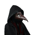 Brown plague doctor mask with rivets worn by hooded person | Chaps London