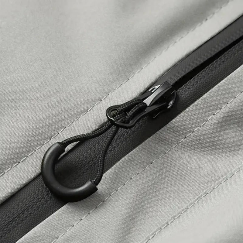 Close-up of gray jacket zipper with black pull cord toggle detail | Chaps London