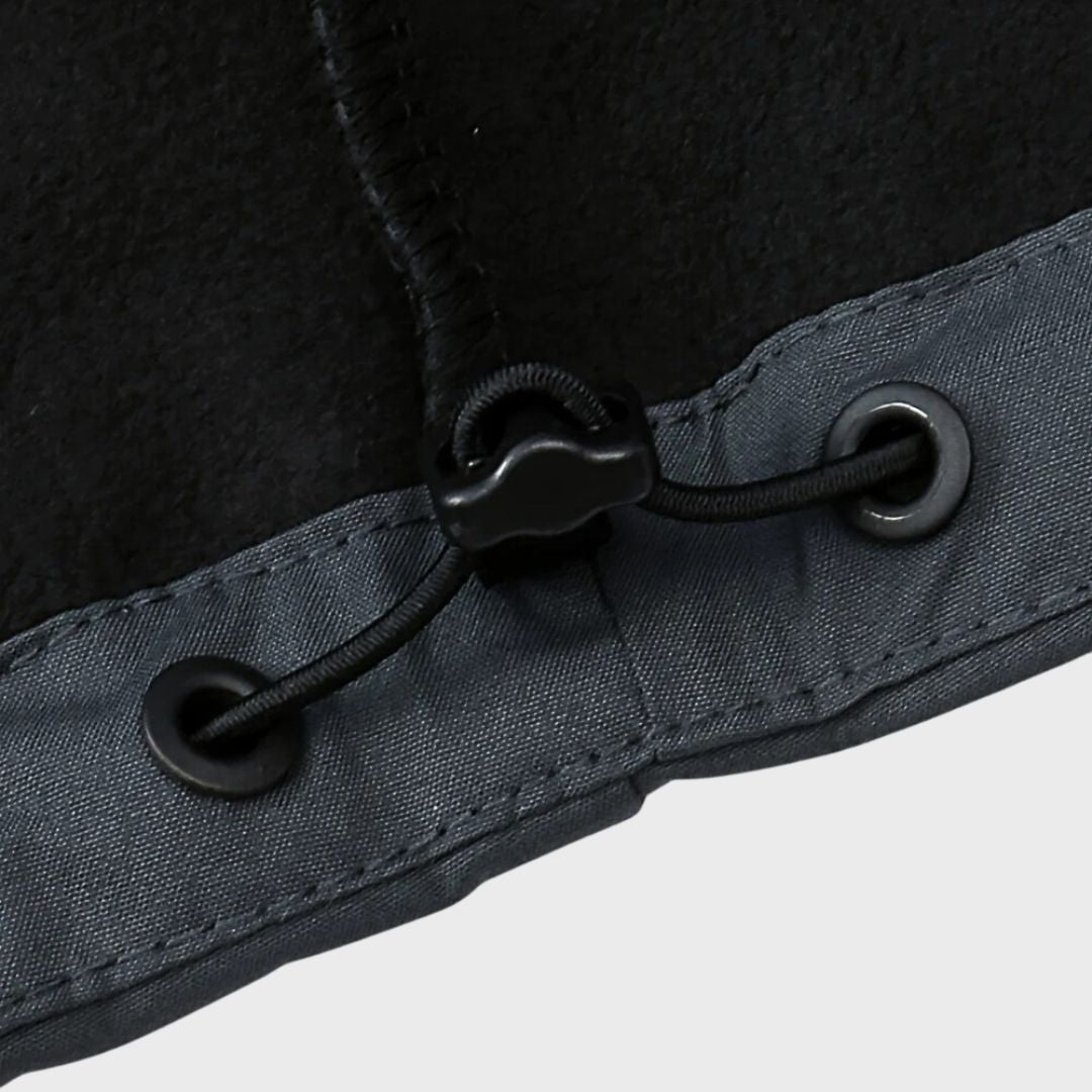 Close-up of black cord lock and grommets on gray jacket hem | Chaps London