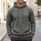 Man wearing grey quilted texture hoodie with chest patch, street background | Chaps London