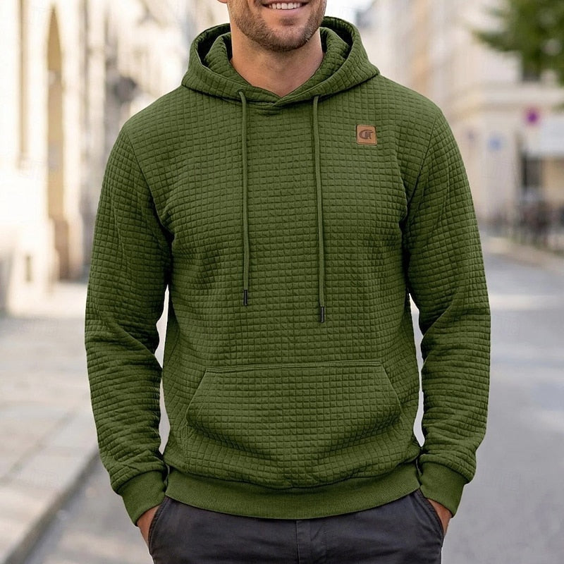 Man wearing olive green quilted-texture hoodie with drawstrings, worn outdoors on street | Chaps London