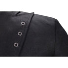 Black asymmetrical jacket with metal grommet buttons, close-up worn by person | Chaps London