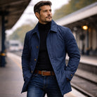 Man wearing navy button-front mac coat with black turtleneck on platform | Chaps London