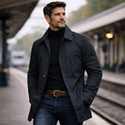 Man wearing navy button-front rain mac with black turtleneck at station | Chaps London