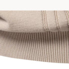 Close-up of beige ribbed knit fabric with contrast stitching detail, folded flat | Chaps London