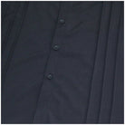 Close-up of black pleated shirt front with buttons, flat lay view | Chaps London