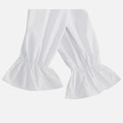 White ruffled cuffs on pants sleeves, worn, close-up view | Chaps London