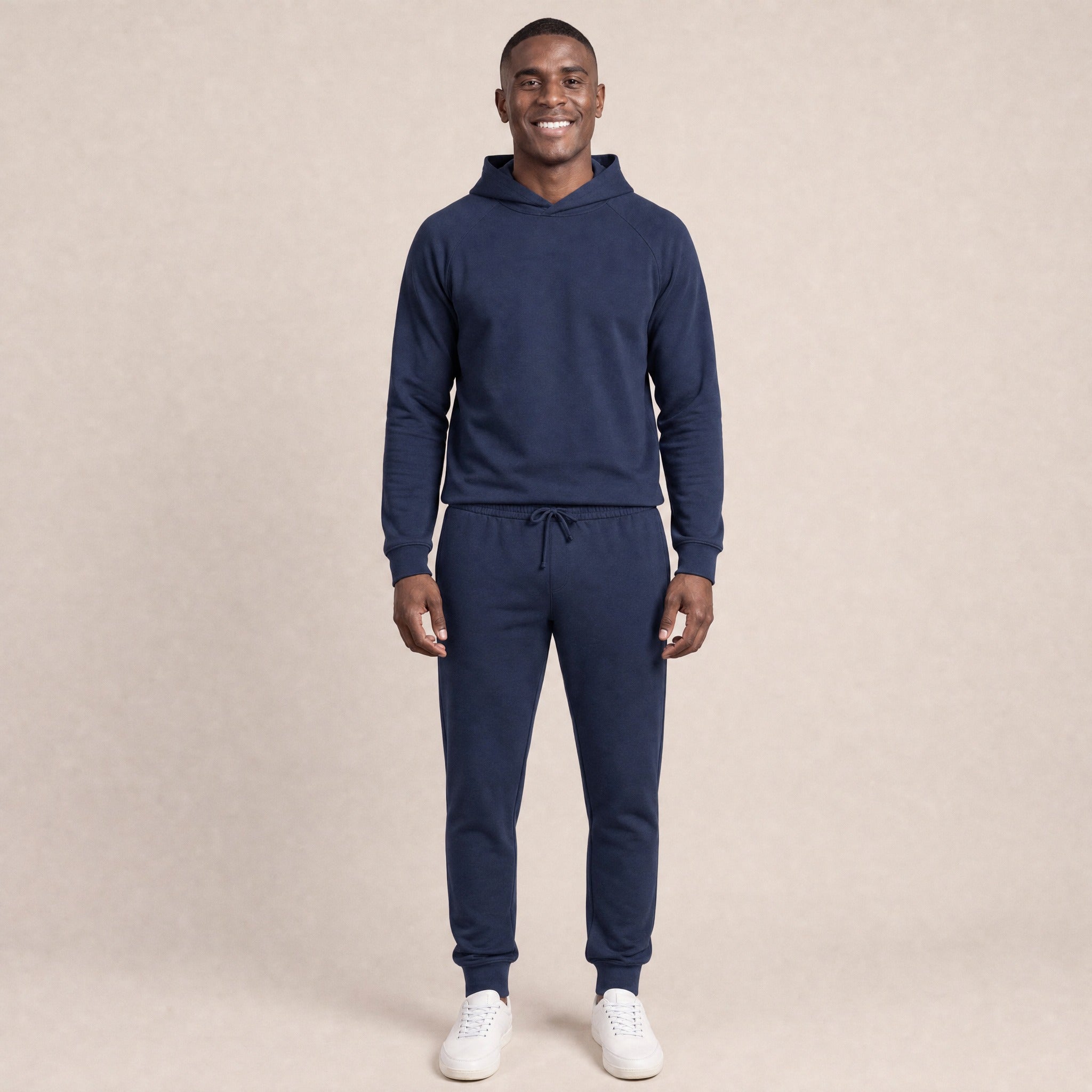 Man wearing navy raglan hoodie and matching joggers, standing, smiling | Chaps London