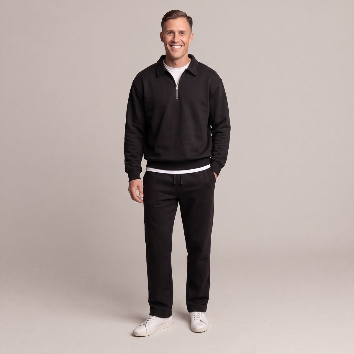 Man wearing black quarter-zip sweatshirt and matching black joggers with sneakers | Chaps London