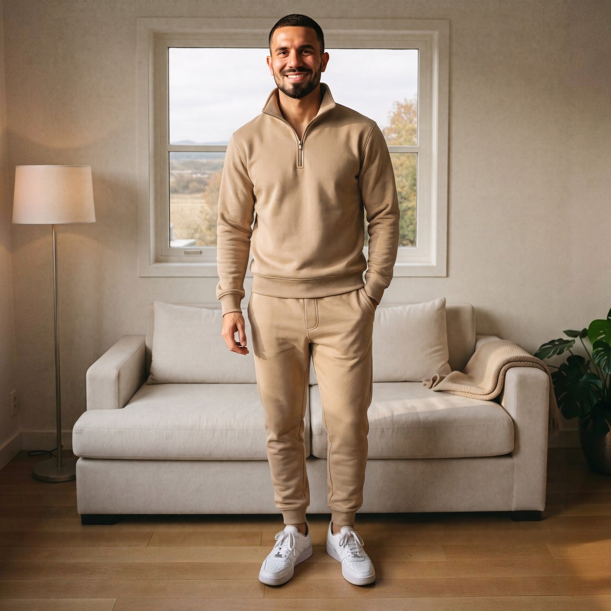 Man wearing beige half-zip tracksuit with joggers, standing in living room | Chaps London