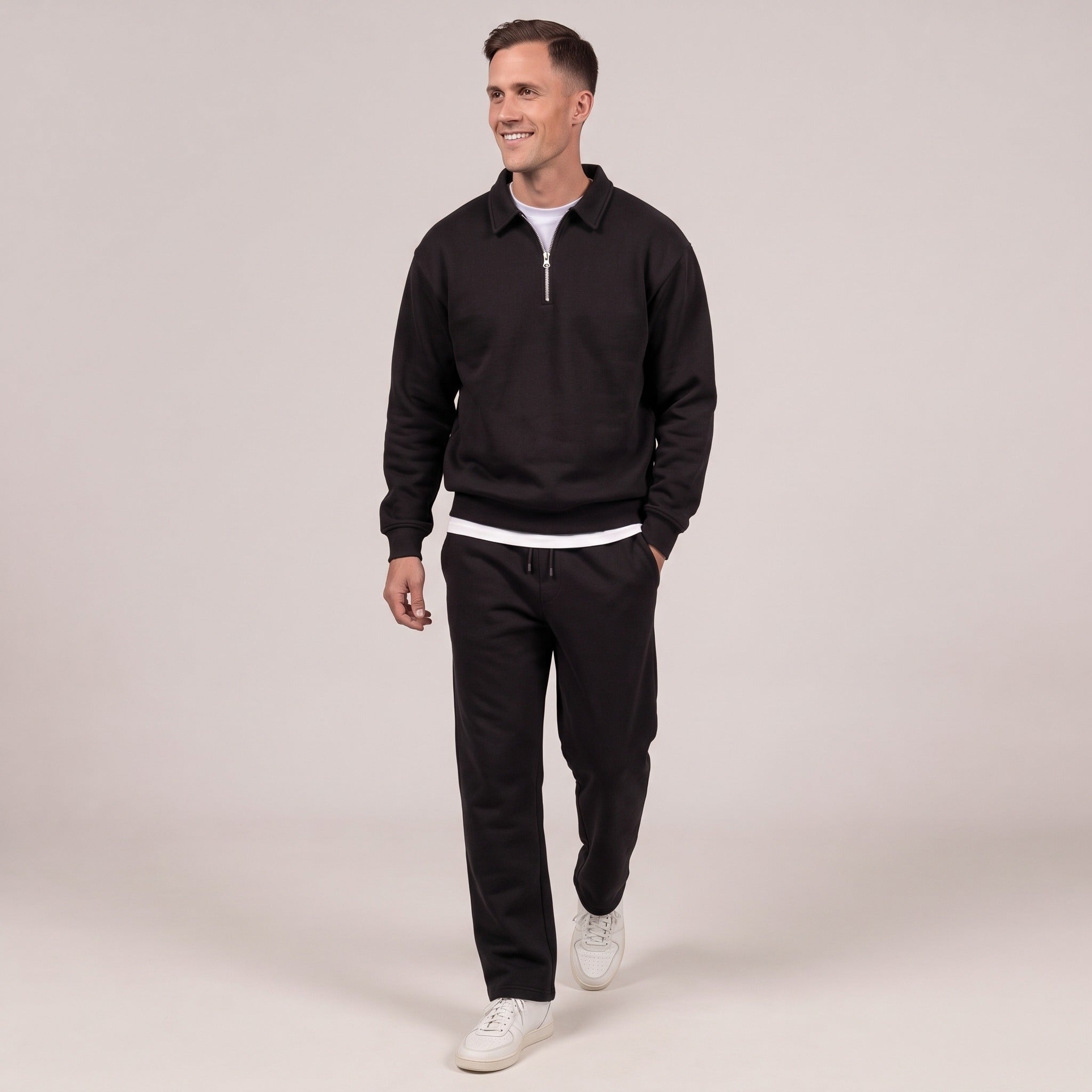 Man wearing black quarter zip sweatshirt with matching black joggers, standing | Chaps London