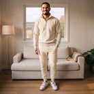 Man wearing cream half zip tracksuit with joggers in living room | Chaps London