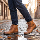 Worn brown leather lace-up biker boots with buckle strap on cobblestone street | Chaps London