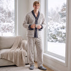 Man wearing gray cable-knit fleece pajama set, holding mug by window | Chaps London