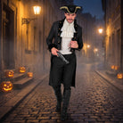 Man wearing black Victorian coat with ruffled shirt on cobblestone street | Chaps London