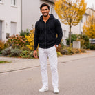 Man wearing black zip hoodie with white pants on street | Chaps London