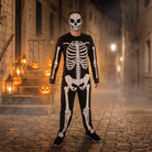 Man wearing black skeleton jumpsuit with mask, standing on cobblestone street | Chaps London
