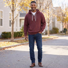 Man wearing maroon half-zip hoodie with white drawcords and jeans outdoors | Chaps London