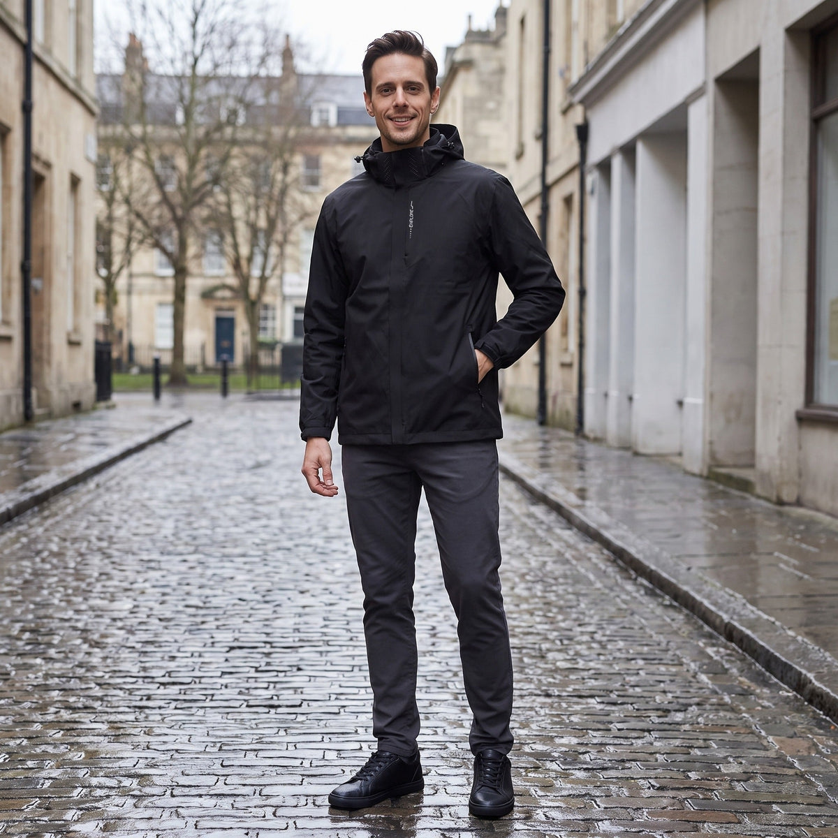 Man wearing black hooded rain jacket and dark trousers on cobblestones | Chaps London