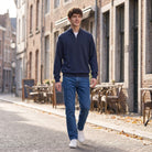 Man wearing navy half zip jumper walking on cobblestone street outdoors | Chaps London
