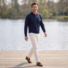 Man wearing navy quarter zip knit jumper with cream trousers outdoors | Chaps London