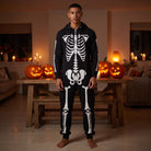Man wearing black hooded skeleton onesie with white bone print, standing indoors | Chaps London