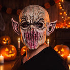 Beige alien monster mask with pointed ears, worn by a person, Halloween scene | Chaps London