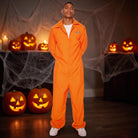 Man wearing orange prisoner jumpsuit costume, standing among Halloween pumpkin decorations | Chaps London
