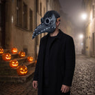 Man wearing black riveted plague doctor mask with goggle eyes, dark coat | Chaps London