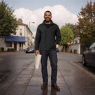 Man wearing black casual rain jacket with jeans, standing on wet street | Chaps London