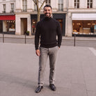 Man wearing black fine knit turtleneck jumper with grey trousers outdoors | Chaps London