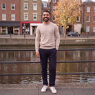 Man wearing beige ribbed knit jumper with navy trousers by riverside | Chaps London