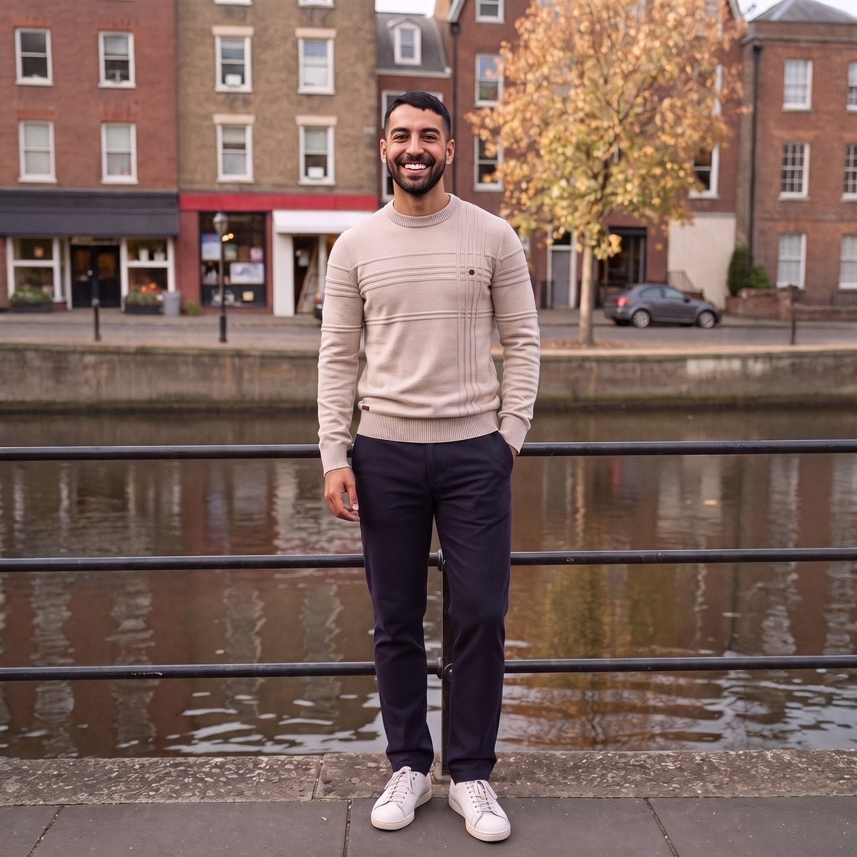 Man wearing beige ribbed knit jumper with navy trousers by riverside | Chaps London