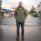 Man wearing olive green hooded windbreaker jacket with jeans on street | Chaps London