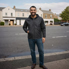 Man wearing black hooded jacket with jeans, standing on street | Chaps London