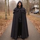 Man wearing black hooded gothic cape, standing on outdoor path | Chaps London